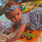 Luna is registered to the contest to win money with this photo: baby, child, play_mat, crawling, headband, dress, indoor, cute, colorful, toy, animal, floor, exploration, star_doodles, infant, childhood, patterned_clothing, playtime, curious, soft_lighting