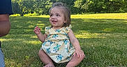 Lailah is registered to the contest to win money with this photo: child, toddler, baby, smiling, sitting, outdoors, grass, park, garden, trees, nature, sunlight, blue_sky, dress, floral_pattern, barefoot, portrait, family, summer, happy