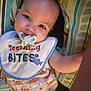baby, infant, pacifier, bib, teething, smiling_crabs, clothing, patterned_cushion, colorful, cute, child, person, lying_down, blue, orange, white, face, eyes, soft_lighting, closeup
