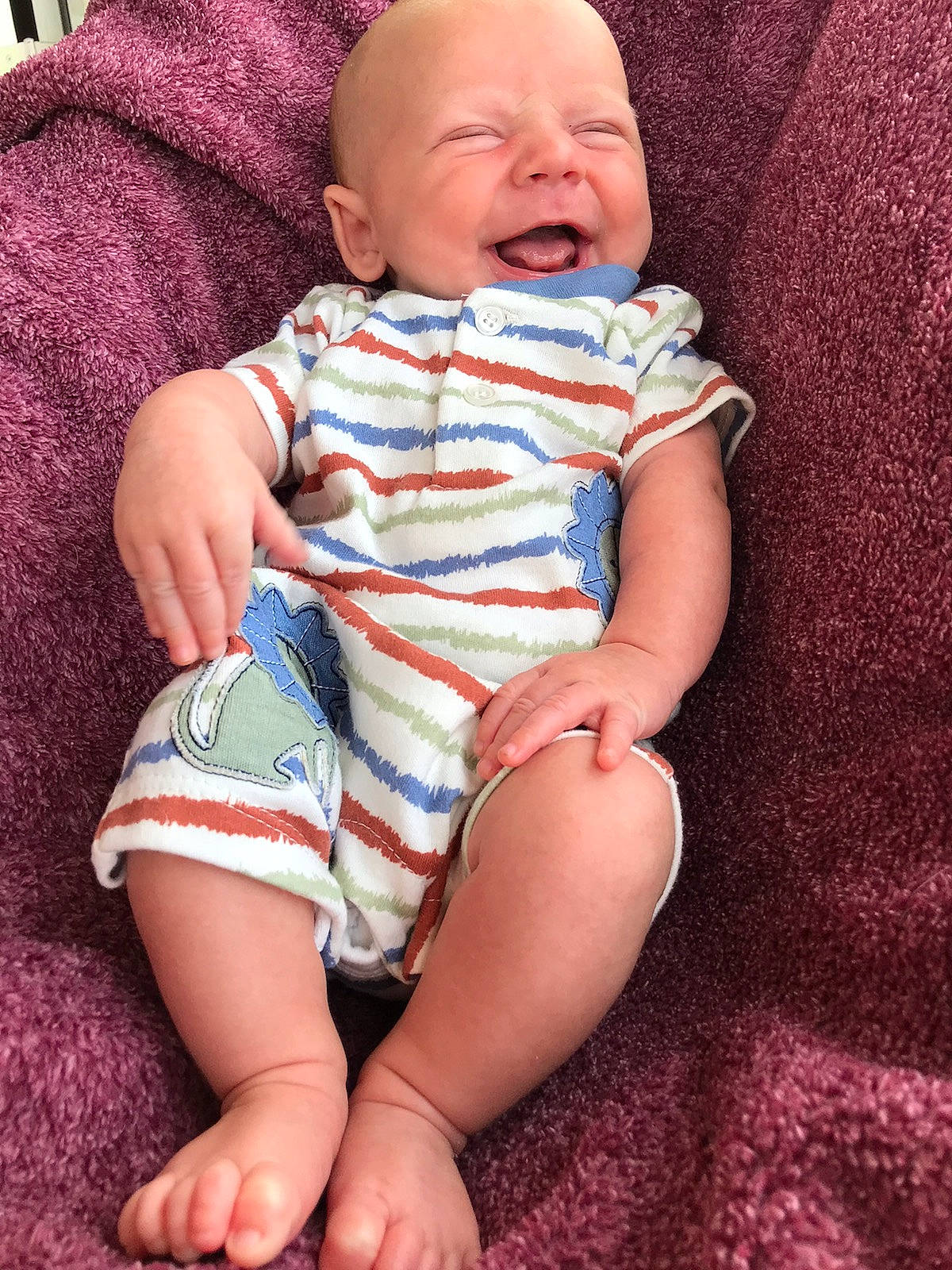 Samuel is registered to the contest to win money with this photo: baby, baby_toddler_clothing, cheek, child, comfort, eye, finger, foot, happy, human_leg, iris, knee, pattern, person, pink, sitting, skin, sleeve, stomach, thigh