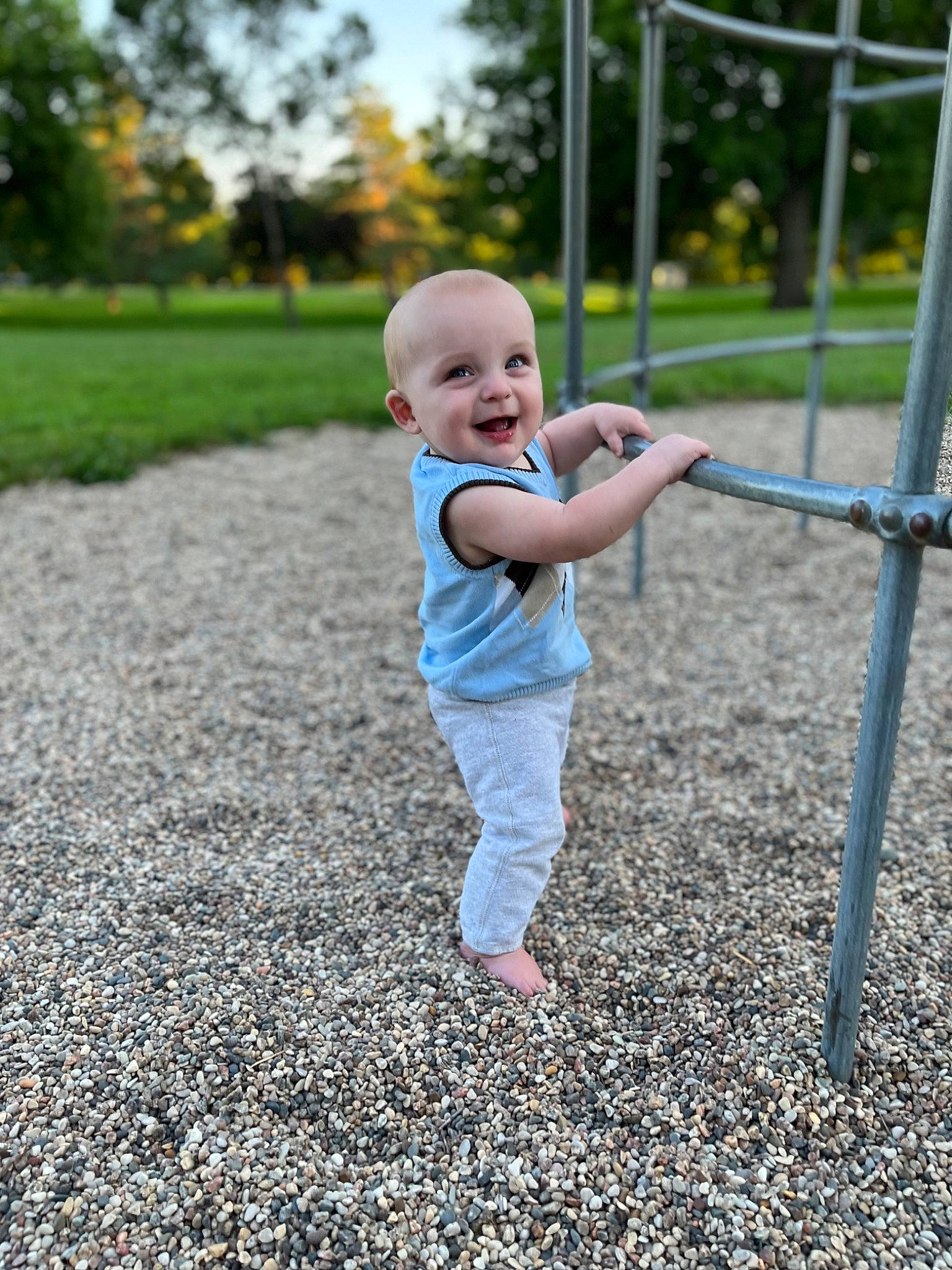 Callen is registered to the contest to win money with this photo: baby, baby_toddler_clothing, botany, child, city, fence, fun, grass, happy, joy, leisure, nature, people_in_nature, person, plant, playground, recreation, smile, standing, t_shirt