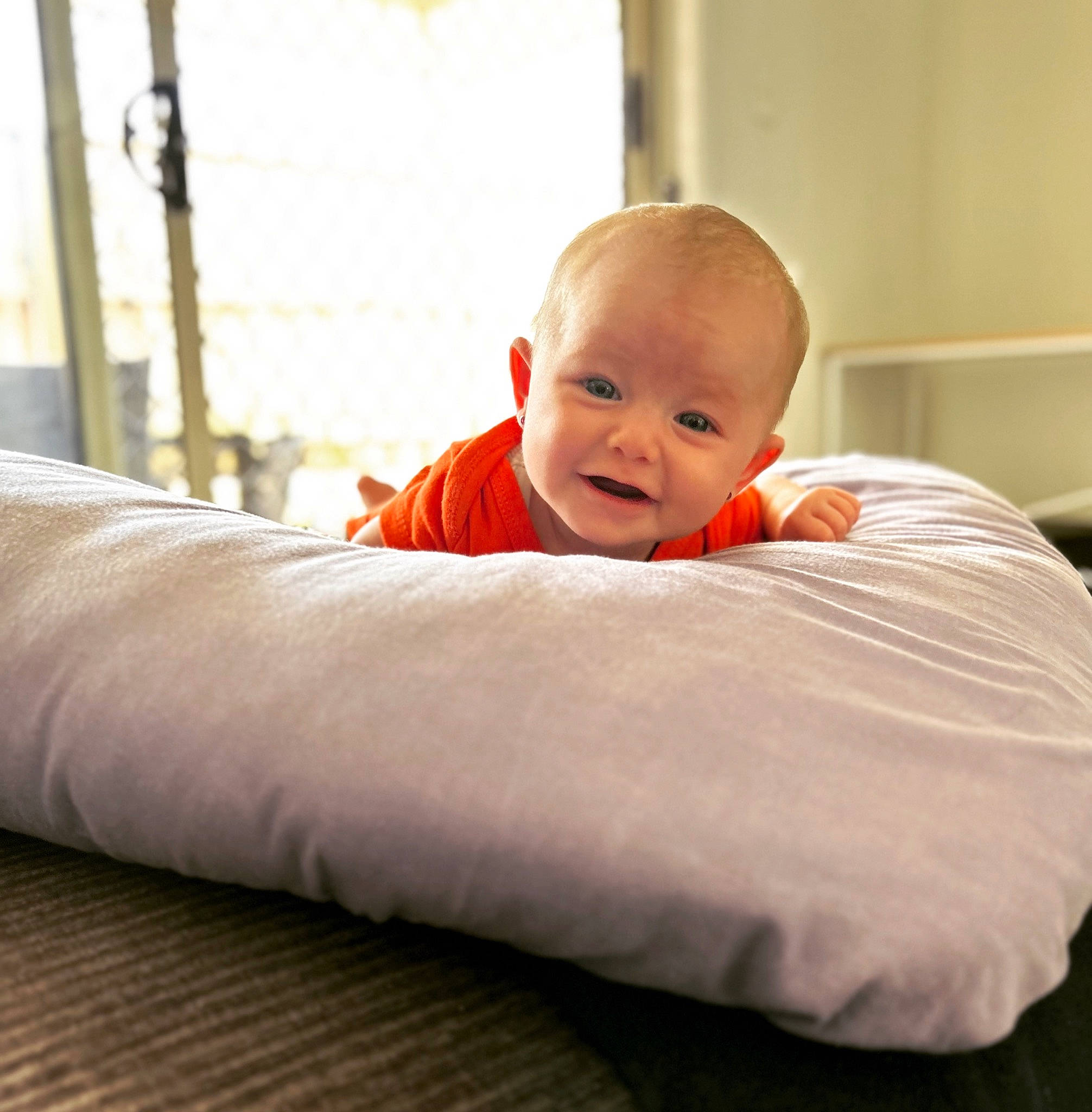 Nova is registered to the contest to win money with this photo: baby, baby_toddler_clothing, bedding, child, comfort, elbow, flooring, happy, hardwood, human_leg, linens, person, portrait_photography, room, sitting, sleeve, smile, thumb, toddler, wood