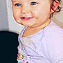 Iris is registered to the contest to win money with this photo: toddler, child, smile, blue_eyes, curly_hair, purple_shirt, cartoon_print, standing, portrait, indoor, cute, happy, baby, face, person, young_child, casual_clothing, bright_eyes, hair_tied_up, playful_expression