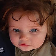 Iris is registered to the contest to win money with this photo: child, toddler, face, curly_hair, blue_eyes, close_up, portrait, indoor, clothing, expression, person, young_child, cute, skin, head, looking, baby, soft_light, casual, curiosity