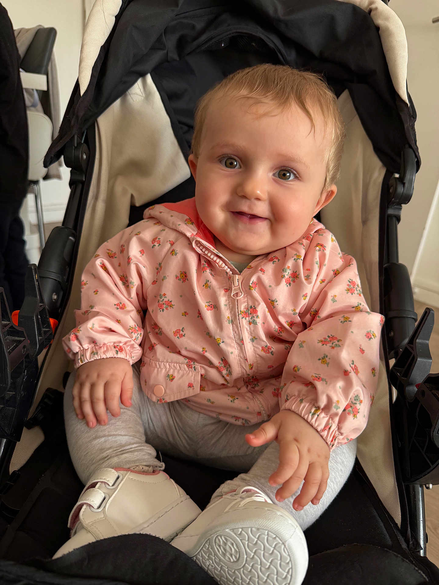 Jihane participe au concours pour gagner de l'argent avec cette photo : baby, child, smile, face, jacket, pink, floral, stroller, shoe, white_shoe, indoor, person, cute, happy, sitting, clothing, hand, legs, portrait, infant