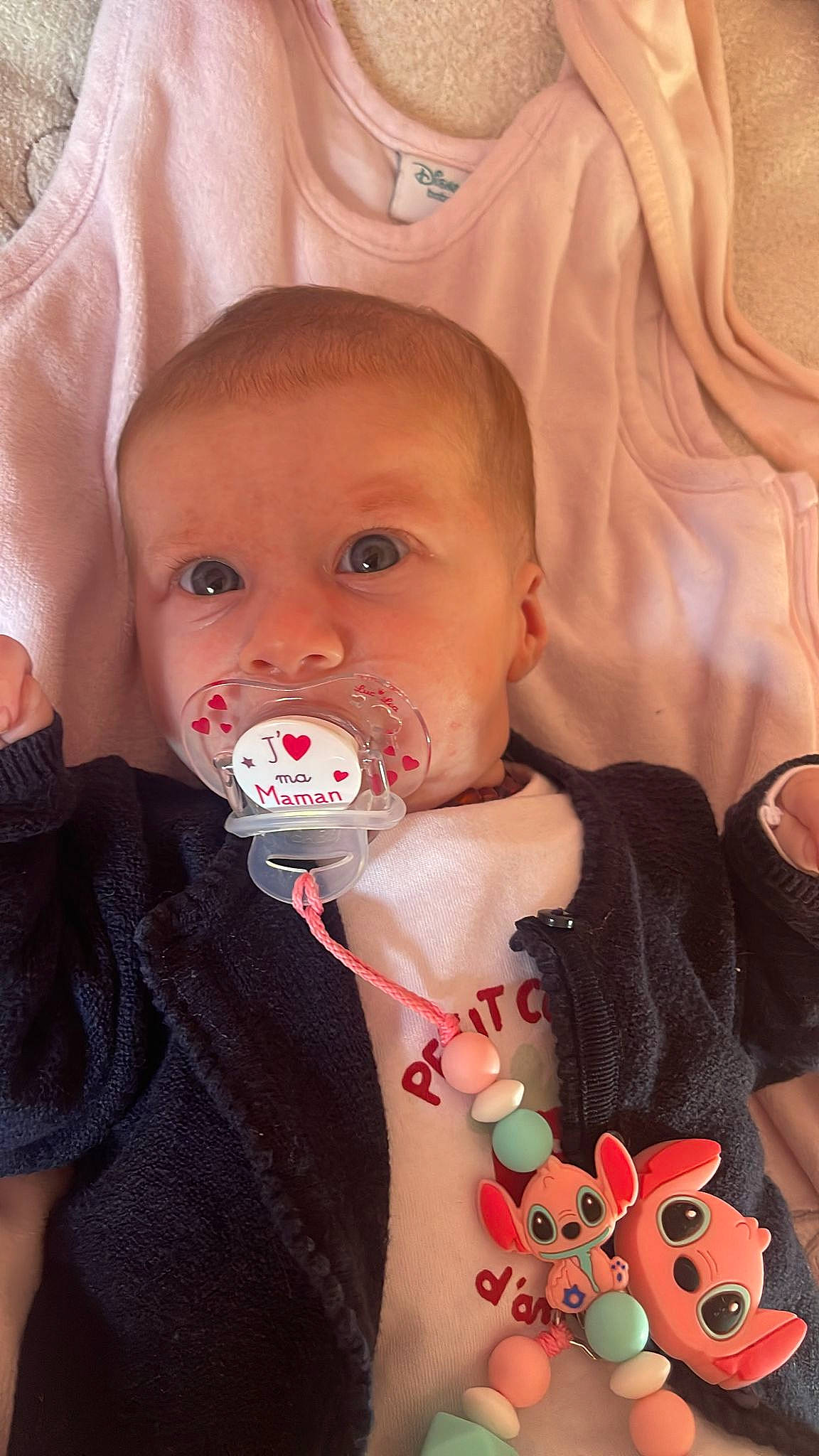 Romy a rejoint le concours — aidez-le/la à gagner de superbes lots ! baby, baby_toddler_clothing, cheek, chin, eyebrow, eyelash, finger, happy, human, iris, lip, mouth, neck, nose, organ, person, pink, skin, sleeve, textile