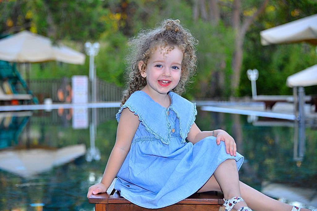 Eva Maria participe au concours pour gagner de l'argent avec cette photo : blond, child, day_dress, dress, electric_blue, flash_photography, fun, grass, happy, human_leg, joy, knee, leisure, person, plant, sitting, smile, spring, summer, thigh