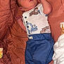 baby, infant, newborn, onesie, blue_pants, lying_down, blanket, quilt, foot, hand, face, sleepwear, cute, indoors, child, soft, resting, cozy, small, portrait