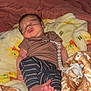 Nash is registered to the contest to win money with this photo: baby, newborn, sleeping, blanket, bed, clothing, striped_pants, brown_shirt, feet, pacifier_clip, soft, cozy, indoors, floral_wallpaper, warm_lighting, infant, person, resting, cute, peaceful