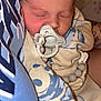 Nash is registered to the contest to win money with this photo: baby, sleeping, pacifier, person, blue_shirt, clothing, closeup, face, infant, cute, cozy, patterned_clothing, resting, newborn, skin, human, portrait, tender, comfort, warm