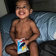 Genesis joined the competition — help win amazing prizes! toddler, child, smiling, bed, pillow, smartphone, diaper, happy, indoors, person, skin, face, hand, furniture, technology, casual, young, cute, playful, expression