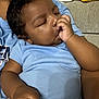 Adrien joined the competition — help win amazing prizes! baby, sleeping, thumb_sucking, blue_onesie, child, person, indoor, couch, arm, curly_hair, peaceful, resting, comfort, skin, infant, closeup, relaxation, soft_lighting, casual_clothing, folded_clothes