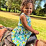 child, girl, pony, horse, ride, outdoor, park, smile, curly_hair, dress, sunlight, nature, trees, grass, happy, animal, young, saddle, summer, playful