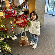Baraa participe au concours pour gagner de l'argent avec cette photo : child, indoor, reindeer, holiday_decor, christmas_tree, decorations, sweater, jeans, boots, carpet, mailbox, furniture, plant, window, smile, person, holiday, festive, toy, light