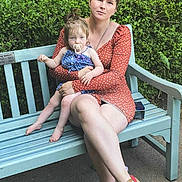 Selena is registered to the contest to win money with this photo: woman, child, bench, greenery, outdoor, dress, polka_dot, pacifier, calm, sitting, nature, park, casual, summer, footwear, person, holding, relaxed, portrait, daylight