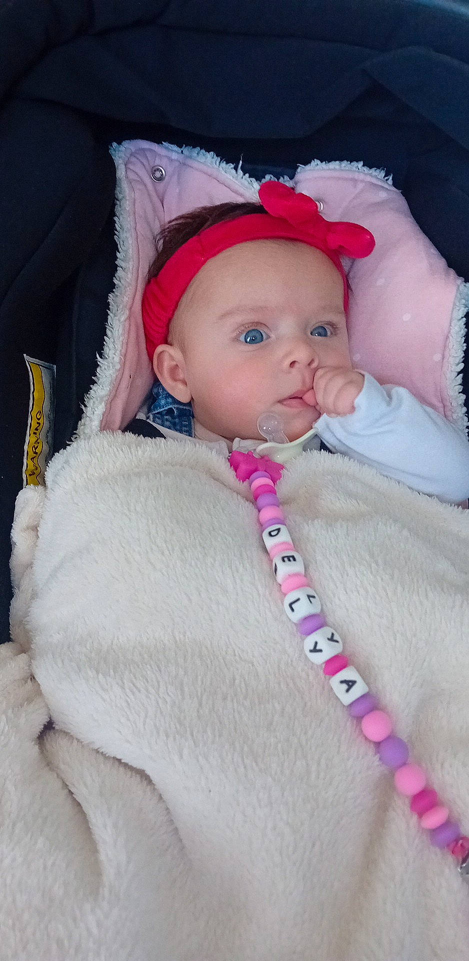 Delya participe au concours pour gagner de l'argent avec cette photo : baby, baby_products, baby_toddler_clothing, cheek, child, comfort, eye, eyelash, face, fashion_accessory, headgear, headwear, iris, lip, magenta, person, pink, sitting, skin, sleeve