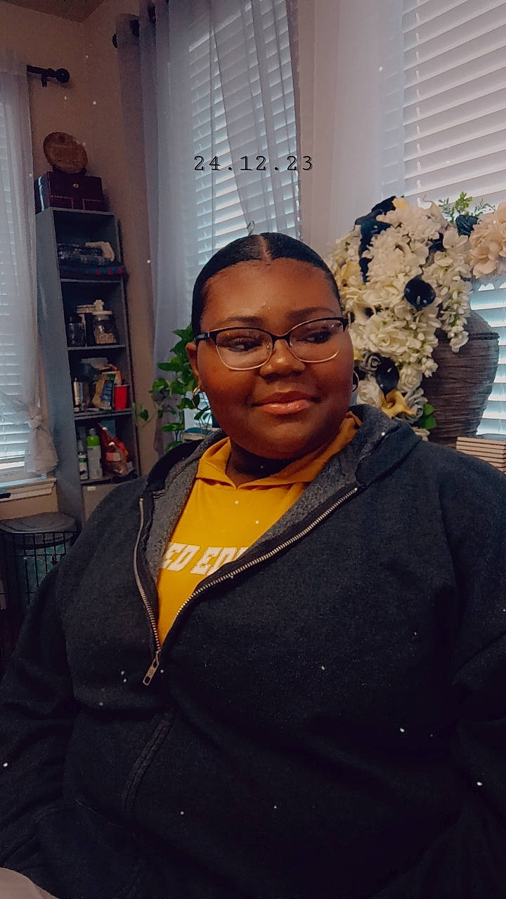 Emonie is registered to the contest to win money with this photo: bookcase, curtain, event, eyewear, fashion_design, forehead, fun, glasses, jewellery, joy, necklace, person, room, shelf, shelving, smile, t_shirt, vision_care, visual_arts, window_blind