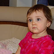 Soleïa participe au concours pour gagner de l'argent avec cette photo : toddler, child, indoor, portrait, pink_dress, blanket, sofa, curly_hair, earrings, cute, young_child, seated, expression, face, person, home, cozy, clothing, soft_lighting, looking_away