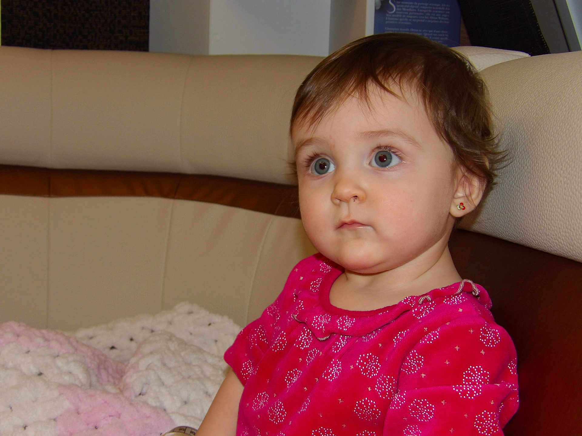 Soleïa participe au concours pour gagner de l'argent avec cette photo : toddler, child, indoor, portrait, pink_dress, blanket, sofa, curly_hair, earrings, cute, young_child, seated, expression, face, person, home, cozy, clothing, soft_lighting, looking_away