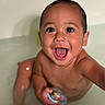 Tom is registered to the contest to win money with this photo: baby, child, bathtub, water, smile, happy, play, toy, skin, face, person, indoors, cute, joy, splash, bath, young, expression, fun, closeup