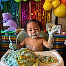 Tom joined the competition — help win amazing prizes! toddler, child, birthday_party, cake, frosting, messy, high_chair, balloons, colorful, celebration, happy, smiling, food, party_decorations, streamers, indoors, fun, face_paint, young_child, table