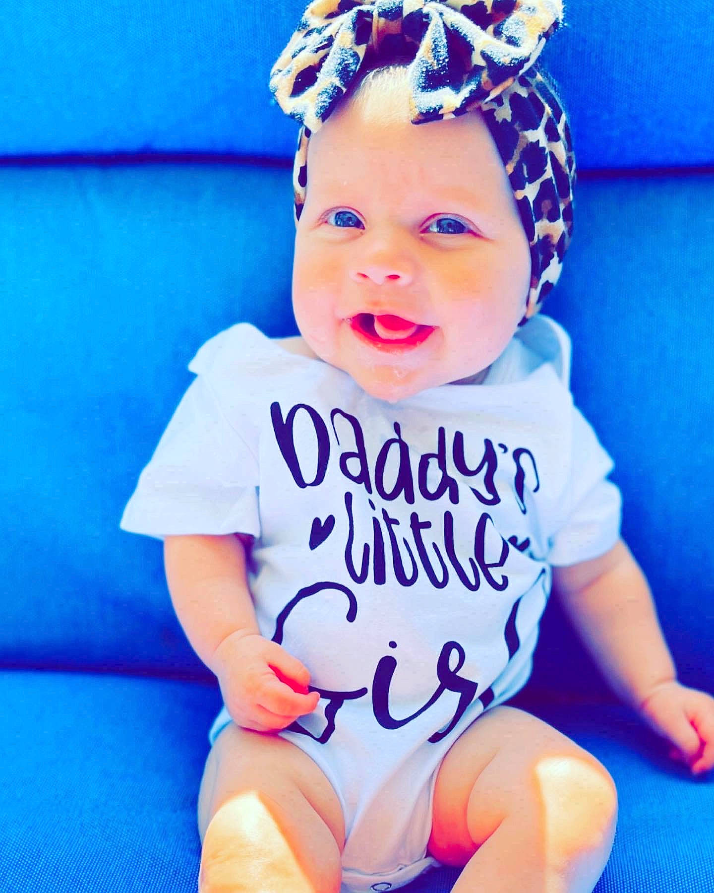 Raelyn is registered to the contest to win money with this photo: arm, azure, baby, baby_toddler_clothing, blue, cap, chin, cool, face, finger, happy, head, headwear, neck, person, photograph, pink, purple, skin, sleeve