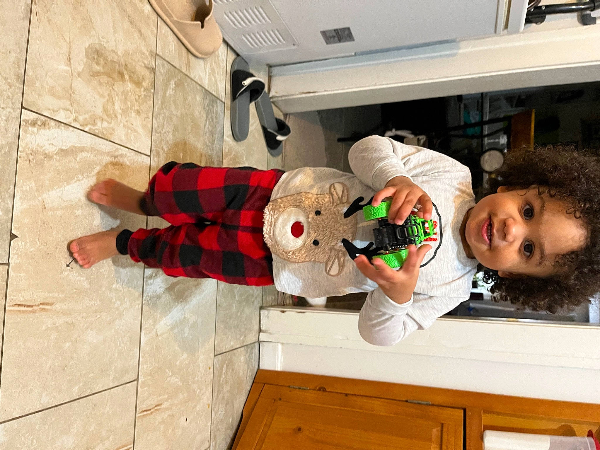 Tru is registered to the contest to win money with this photo: cabinetry, chest_of_drawers, child, cupboard, drawer, event, flooring, holiday, joy, kitchen, machine, pattern, person, room, smile, stuffed_toy, t_shirt, toddler, toy, wood