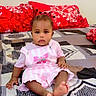 Afrah joined the competition — help win amazing prizes! baby, child, infant, bed, bedding, pillow, red_pillow, patterned_bedspread, pink_dress, striped_dress, bow, barefoot, indoors, sitting, portrait, cute, calm, person, floor_covering, home