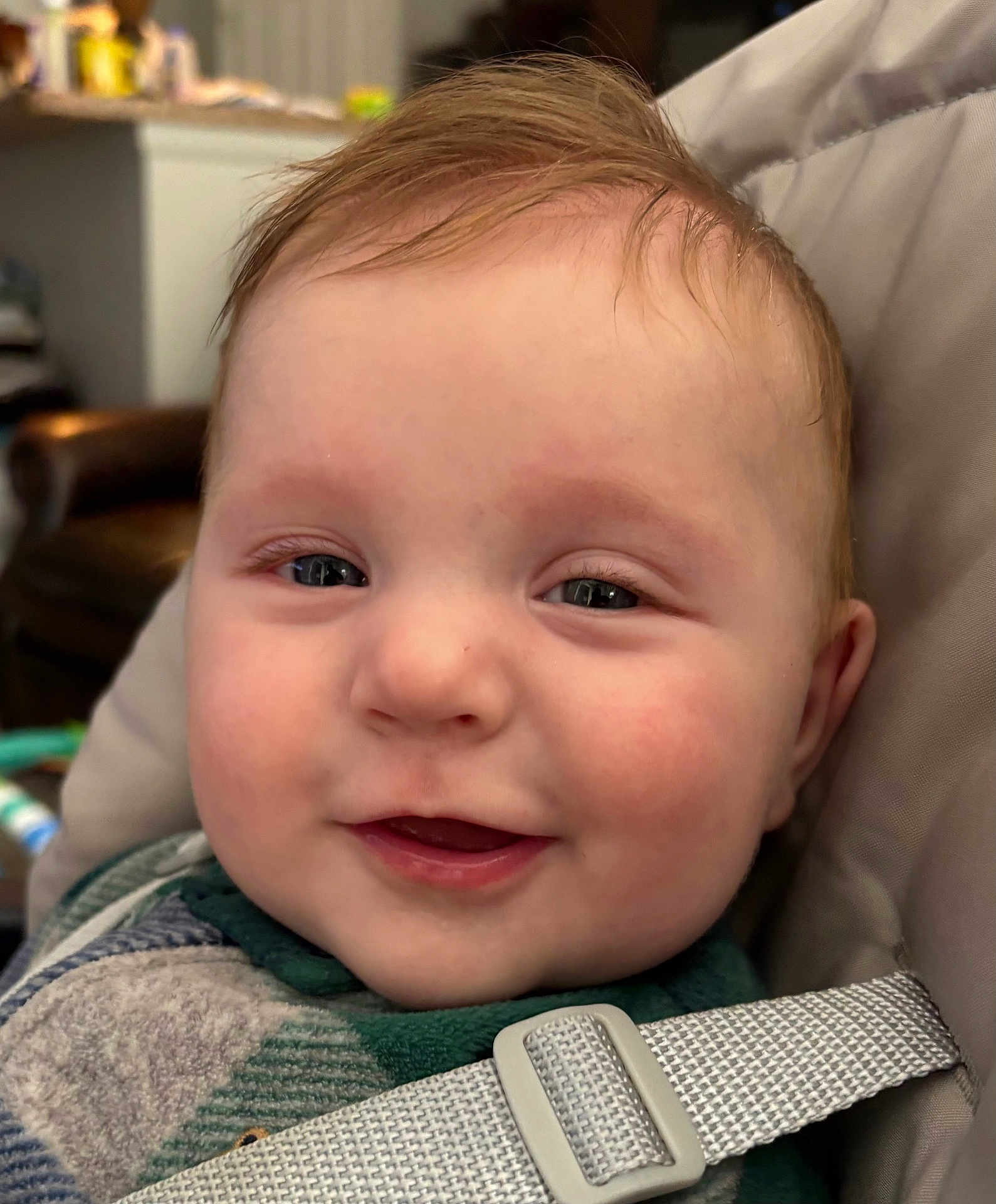 Elyon is registered to the contest to win money with this photo: baby, smiling, face, close_up, child, infant, seatbelt, straps, indoor, cute, happy, skin, hair, person, young_child, portrait, expressive, cheeks, eyes, comfortable