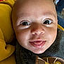 baby, close_up, smiling, tongue_out, face, eyes, infant, yellow_blanket, clothing, lion_patch, cute, child, portrait, soft_light, indoor, person, skin, head, happy, young