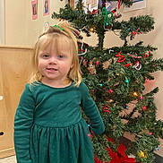 Rylee joined the competition — help win amazing prizes! celebration, child, christmas_tree, decorations, dress, festive, floor, girl, green_dress, hair_tie, happy, holiday, indoor, lights, person, photos, seasonal, smile, wall, young_child