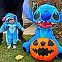 baby, child, costume, blue, inflatable, pumpkin, halloween, grass, adult, support, outdoor, house, holiday, cute, smiling, celebration, fall, leaves, footwear, person