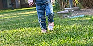 Ashanti is registered to the contest to win money with this photo: toddler, child, grass, outdoor, smiling, happy, denim_overalls, pink_sneakers, waving, sunlight, backyard, trees, barbecue_grill, person, nature, daylight, playful, cute, casual_clothing, young_child