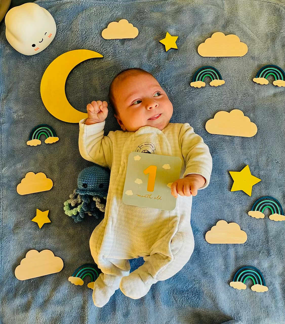 Owen a rejoint le concours — aidez-le/la à gagner de superbes lots ! baby, infant, one_month_old, blanket, wooden_stars, wooden_clouds, wooden_rainbows, crocheted_toy, octopus, cute, smiling, lying_down, soft_toys, child, newborn, indoors, colorful, happy, playful, portrait
