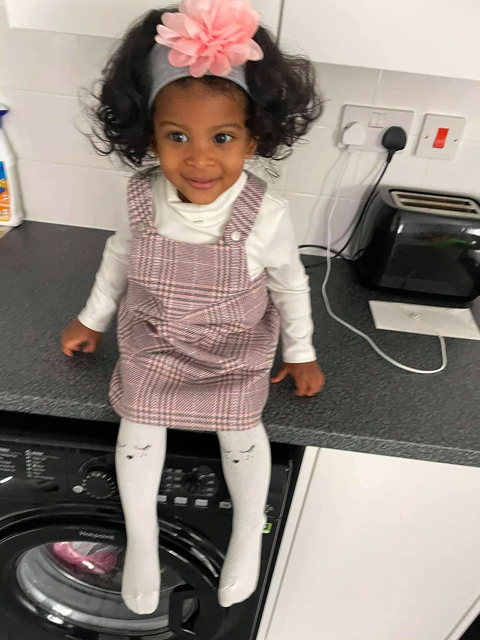 Amiah is registered to the contest to win money with this photo: arm, automotive_tire, baby_toddler_clothing, child, clothing, dress, flower, hair, hairstyle, hand, happy, joy, leg, pattern, person, skin, sleeve, smile, snapshot, standing