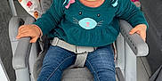 Lüna participe au concours pour gagner de l'argent avec cette photo : toddler, child, high_chair, smiling, blue_eyes, sweater, cat_design, jeans, boots, indoor, floor_tiles, furniture, playful, happy, seat_belt, home, patterned_fabric, cute, baby, person