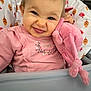 baby, child, smile, blue_eyes, pink_clothing, plush_toy, high_chair, pattern, leaf_pattern, bird_pattern, cute, indoor, portrait, happy, face, infant, toddler, cozy, soft_toy, pink