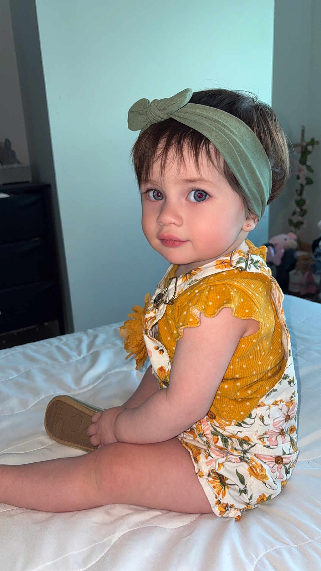Zaiori joined the competition — help win amazing prizes! toddler, child, bed, clothing, headband, yellow_top, floral_overalls, indoor, portrait, cute, sitting, person, baby, face, skin, hair, hand, footwear, furniture, soft_lighting