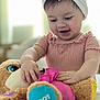 Zaiori is registered to the contest to win money with this photo: toddler, child, baby, headband, bow, pink_clothing, plush_toy, stuffed_animal, indoor, soft_lighting, happy, smiling, hands, face, play, cute, cozy, young_child, person, closeup