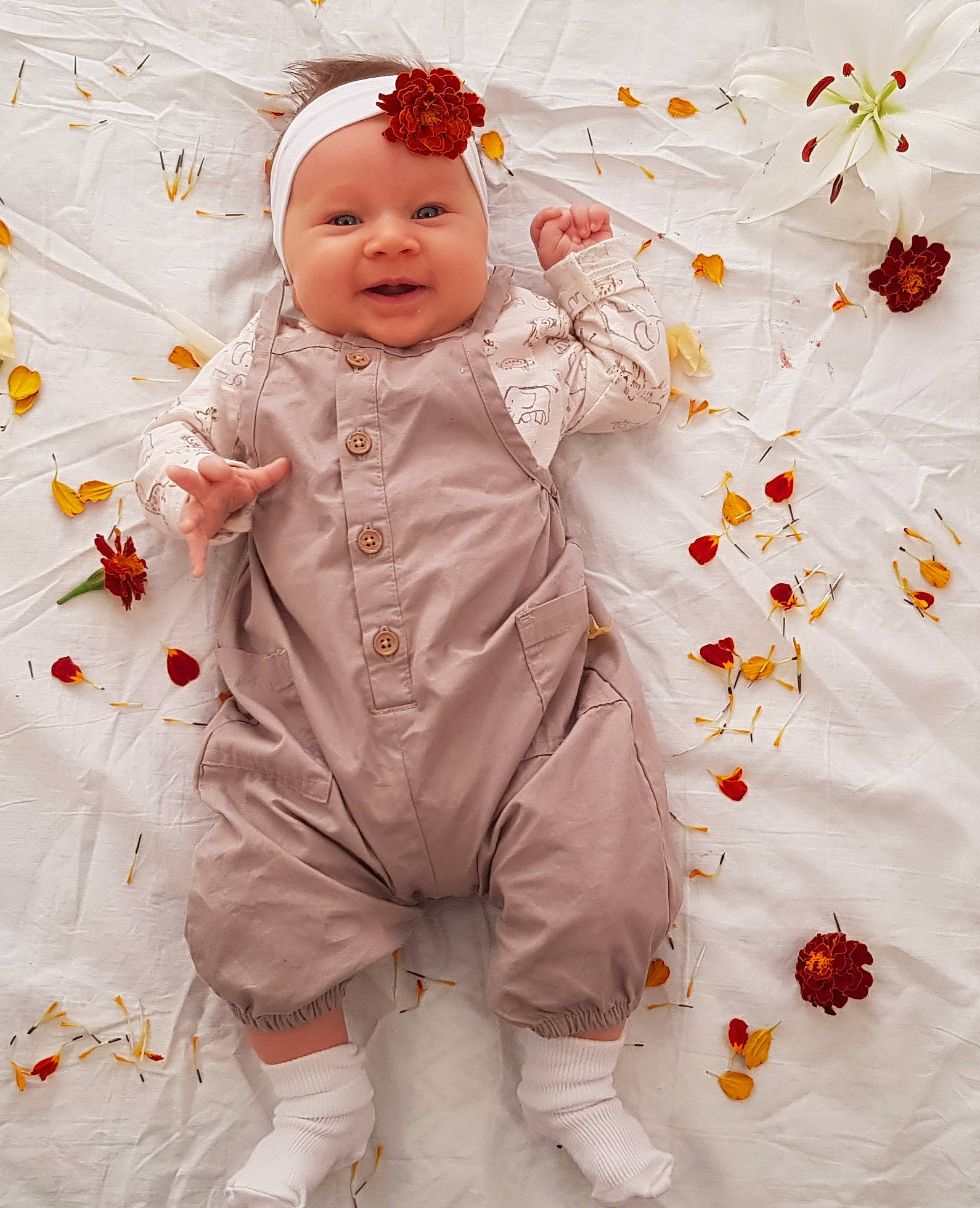 Hannah is registered to the contest to win money with this photo: baby, baby_toddler_clothing, baby_toys, child, costume_hat, flooring, formal_wear, happy, headwear, linens, orange, pattern, peach, person, play, room, sleeve, smile, textile, toddler