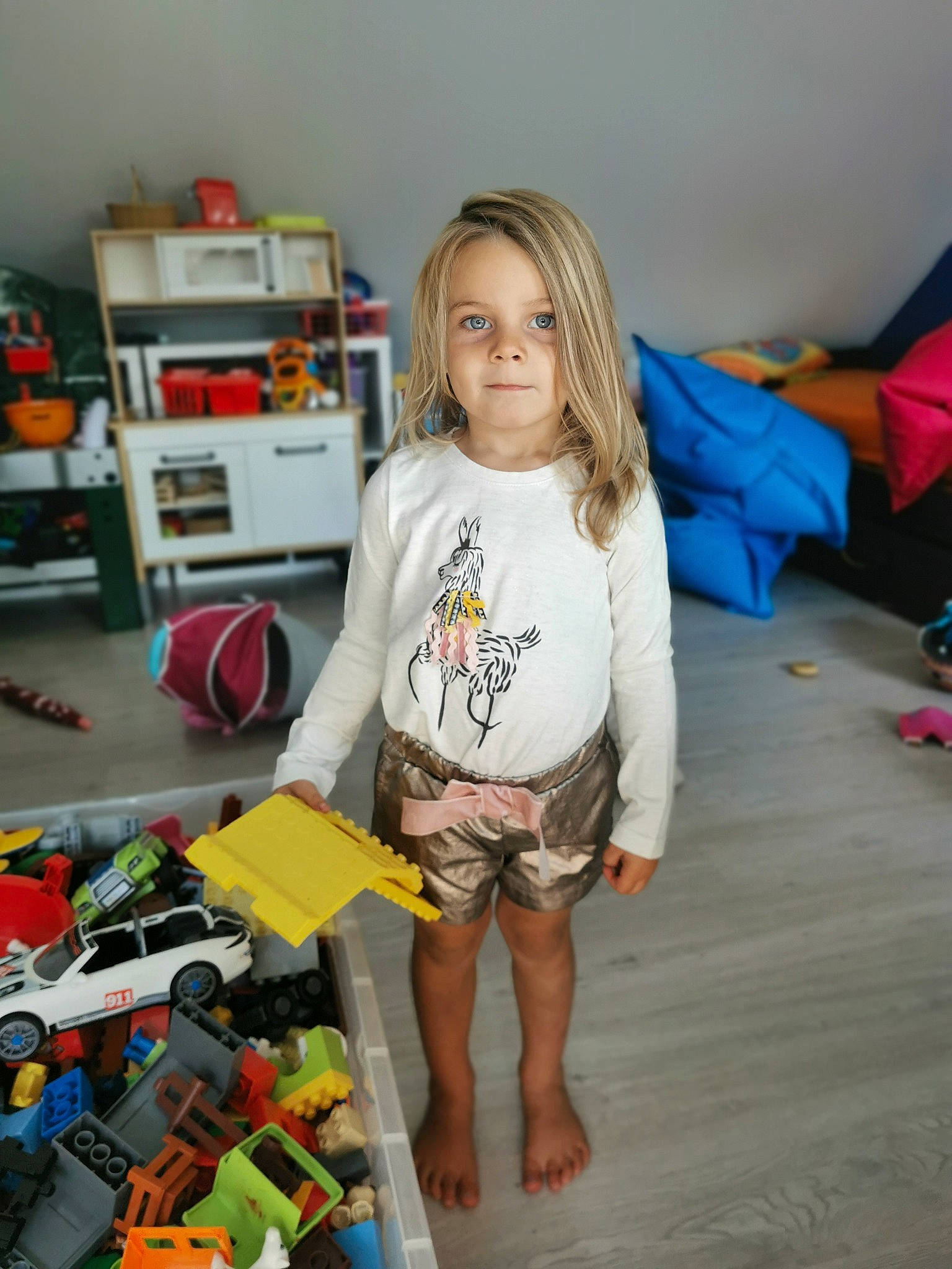 Juline a rejoint le concours — aidez-le/la à gagner de superbes lots ! box, child, engineering, event, floor, flooring, fun, hardwood, human_leg, knee, person, play, room, shelf, shelving, shorts, sitting, t_shirt, toddler, toy