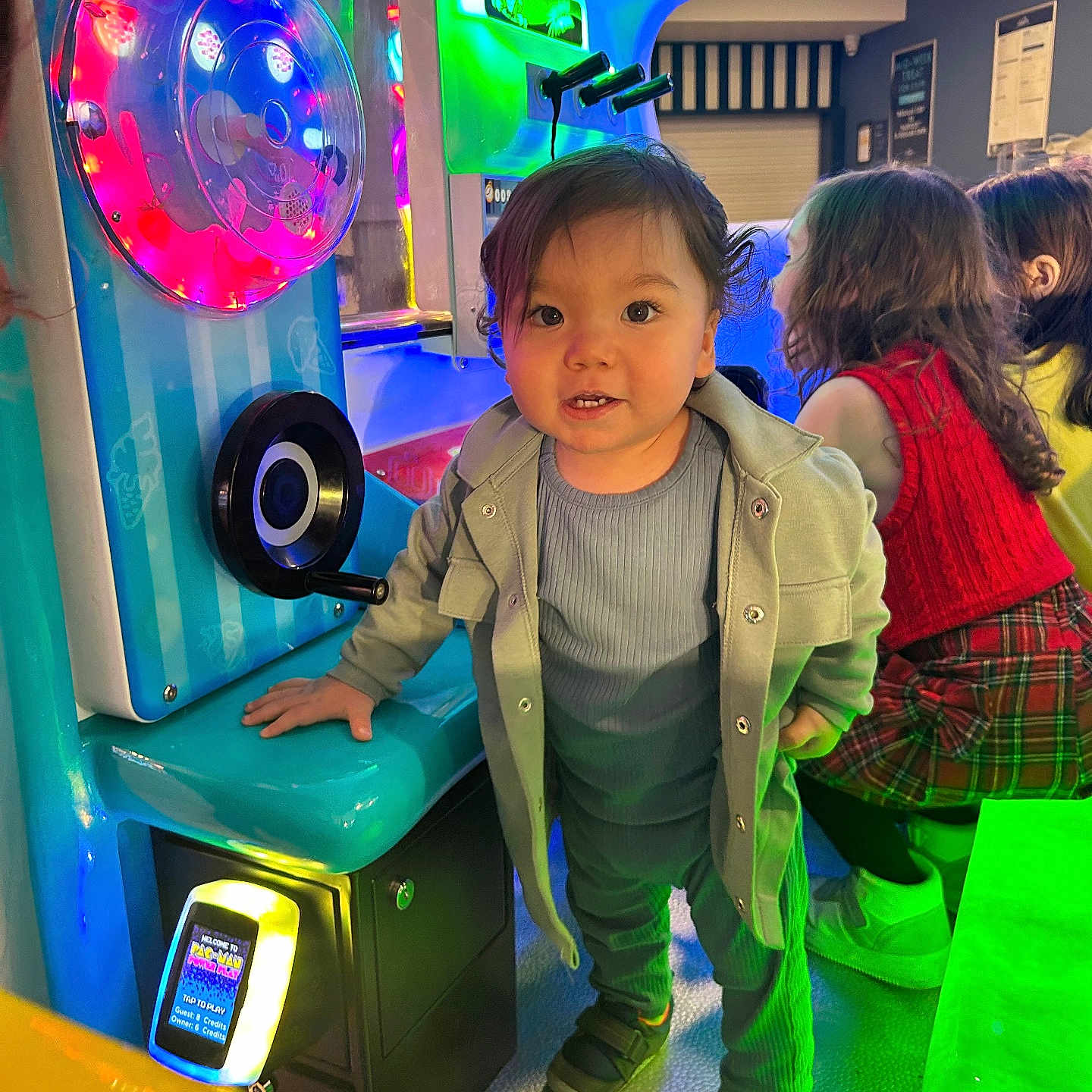 Logan-Levy is registered to the contest to win money with this photo: arcade, child, clothing, colorful_lights, curious, entertainment, fun, game_machine, girls, hair, happy, indoor, jacket, people, play, portrait, smile, sneakers, technology, toddler