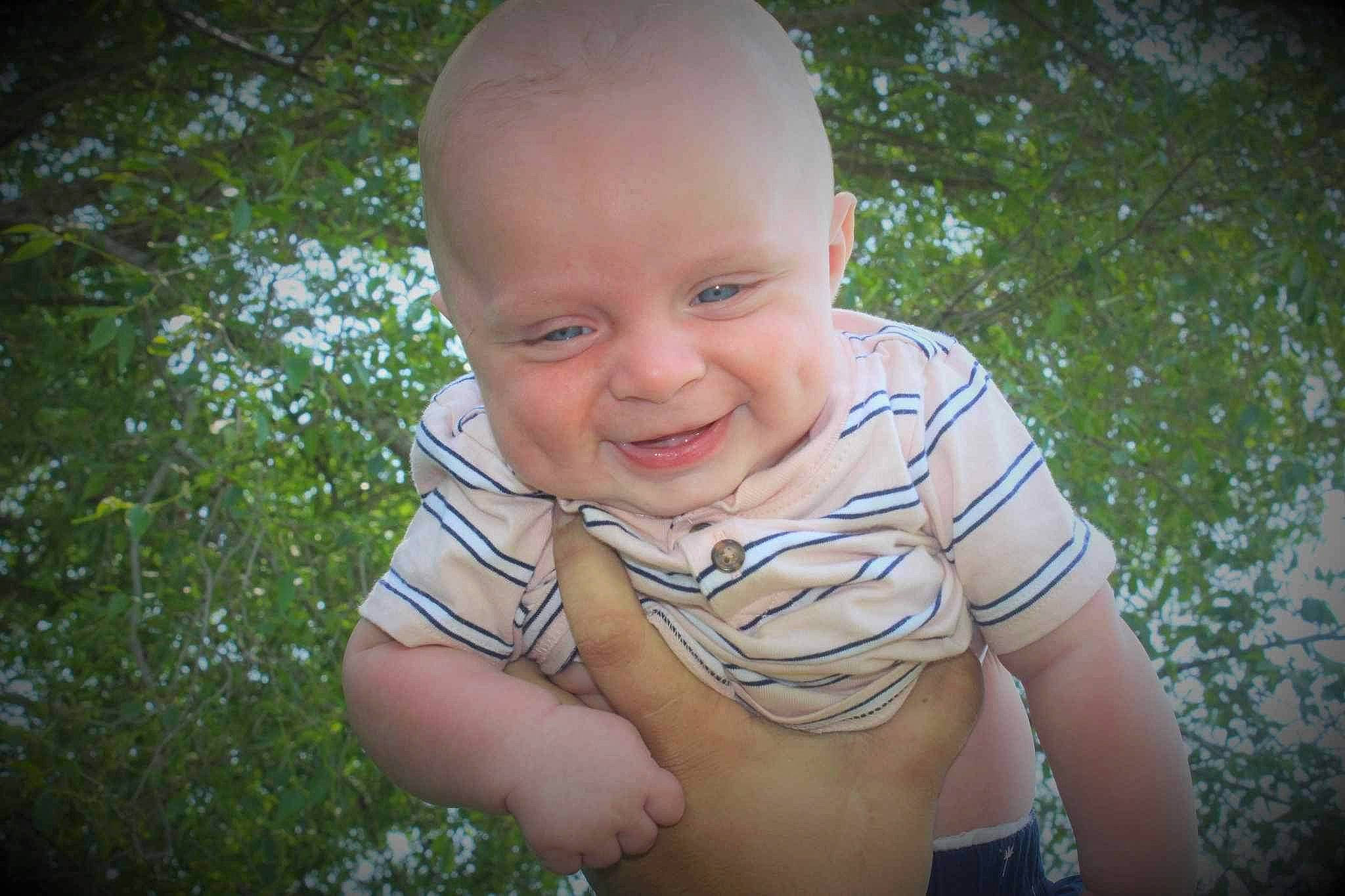 Brexston is registered to the contest to win money with this photo: arm, baby, baby_toddler_clothing, finger, flash_photography, gesture, grass, hand, happy, iris, joy, leaf, mouth, nose, people_in_nature, person, plant, skin, smile, sunlight