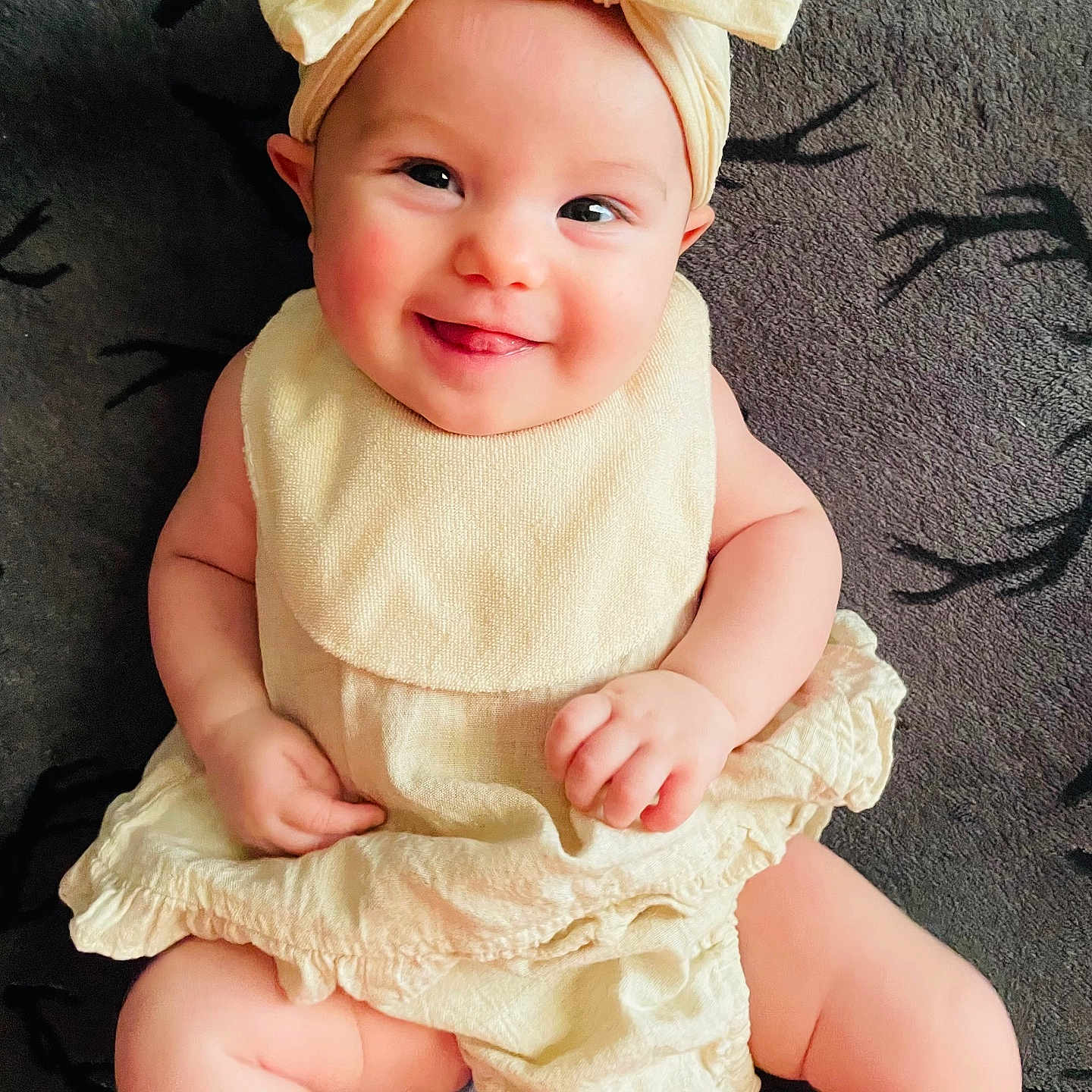 Remy joined the competition — help win amazing prizes! baby, child, smile, headband, bow, infant, clothing, cute, happy, sitting, blanket, pattern, skin, face, portrait, indoors, young, person, toddler, apparel