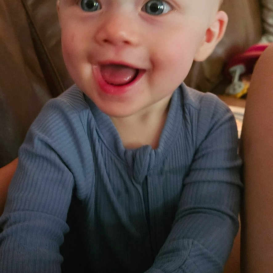 Halston joined the competition — help win amazing prizes! baby, child, infant, smiling, happy, laughing, portrait, face, blue_eyes, indoor, couch, leather, lamp, home, living_room, sitting, shirt, long_sleeves, close_up, photography