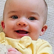 Haisley joined the competition — help win amazing prizes! baby, child, infant, smiling, happy, portrait, close_up, yellow_clothing, long_sleeves, blanket, fluffy, hand, face, eyes, ears, indoor, textile, couch, photograph, smartphone_screenshot