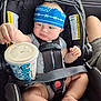 baby, car_seat, bandana, drink, straw, clothing, seat_belt, child, infant, car_interior, person, cute, expression, hand, foot, headwear, sitting, safety_harness, drink_cup, pout
