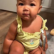 Braelynn joined the competition — help win amazing prizes! baby, child, indoor, yellow_outfit, pacifier, floor, carpet, door, furniture, person, infant, curly_hair, skin, face, expression, sitting, drool, clip, video_call, home