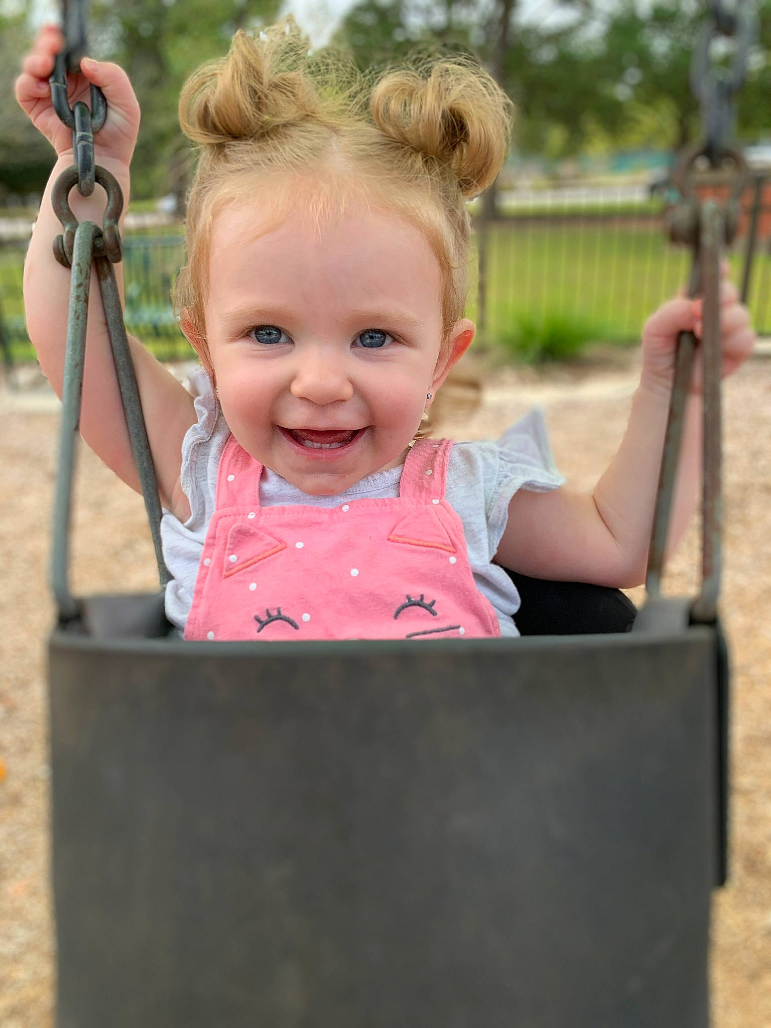 Madisyn is registered to the contest to win money with this photo: baby, blond, cheek, child, eye, face, fun, head, human_settlement, joy, outdoor_play_equipment, person, pink, play, playground, public_space, skin, smile, summer, swing