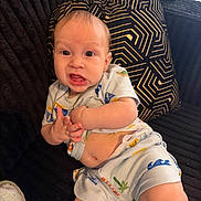 Thiago joined the competition — help win amazing prizes! baby, infant, child, pajamas, couch, pillow, expression, face, skin, hand, footwear, home, indoor, person, cute, young, sitting, clothing, pattern, texture